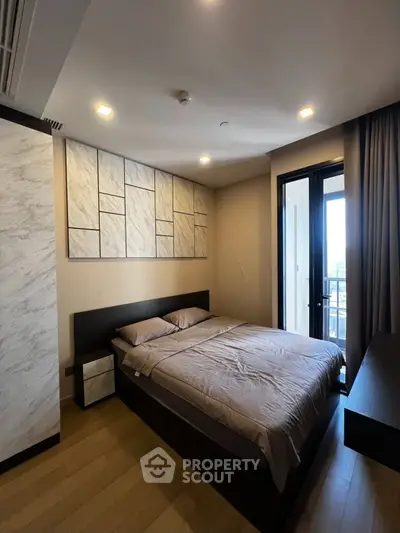 Modern bedroom with stylish decor and balcony access in a luxury apartment.