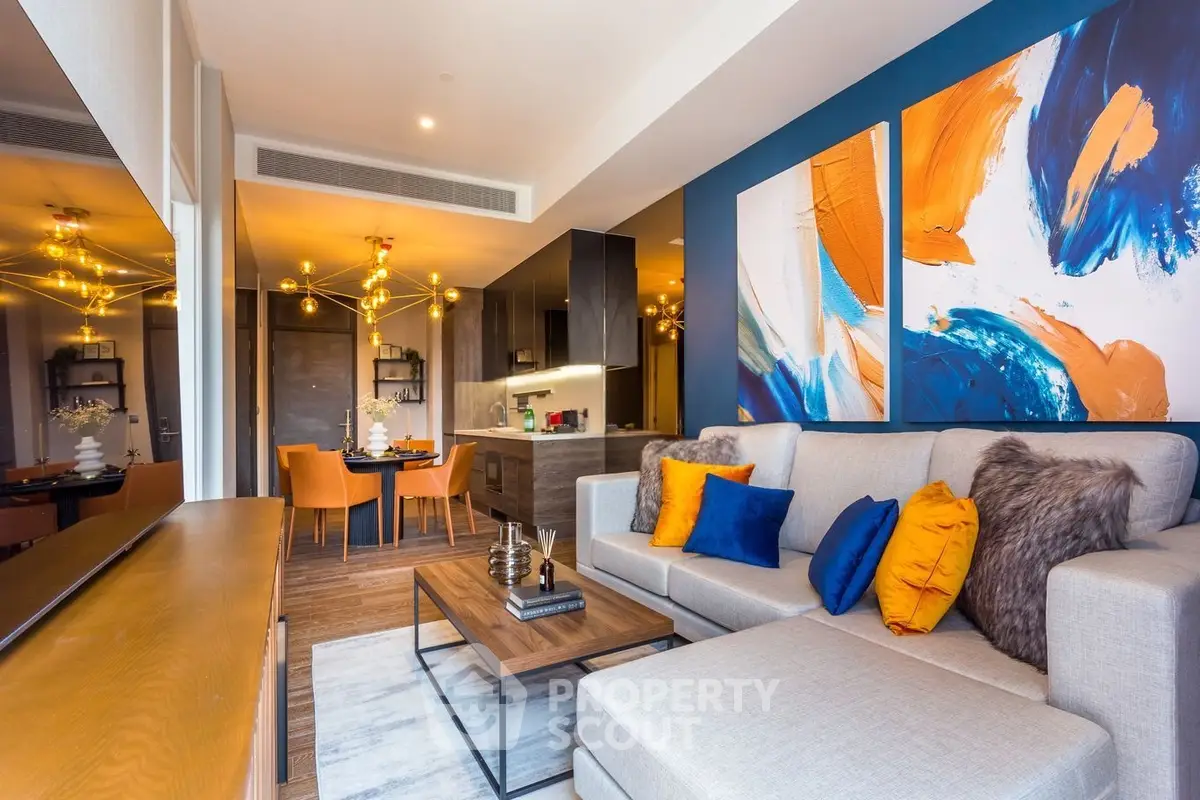 Modern living room with vibrant decor and open kitchen layout in luxury apartment.