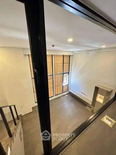 Modern duplex interior with high ceilings and large windows
