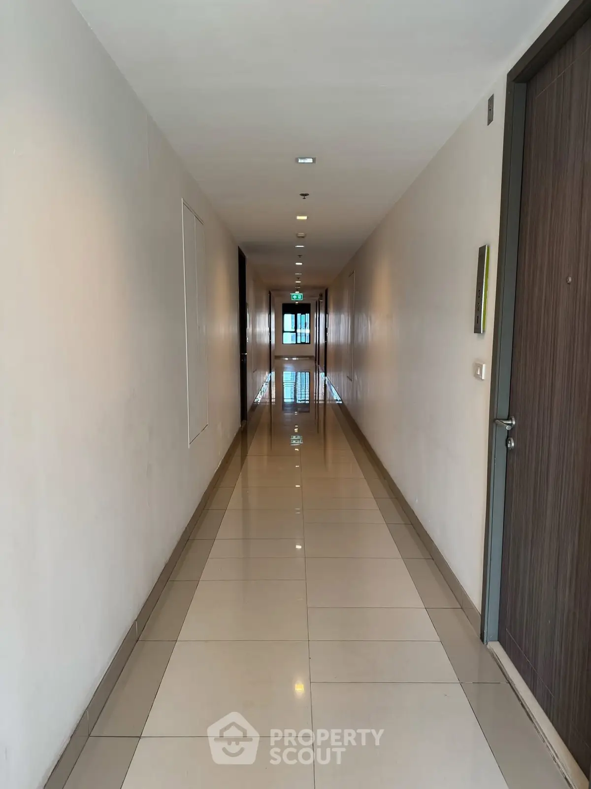 Modern apartment hallway with sleek tile flooring and ambient lighting.