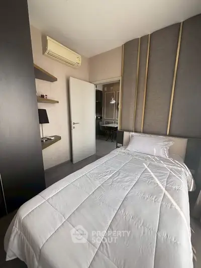 Modern bedroom with sleek design and air conditioning, featuring a cozy single bed and stylish wall paneling.