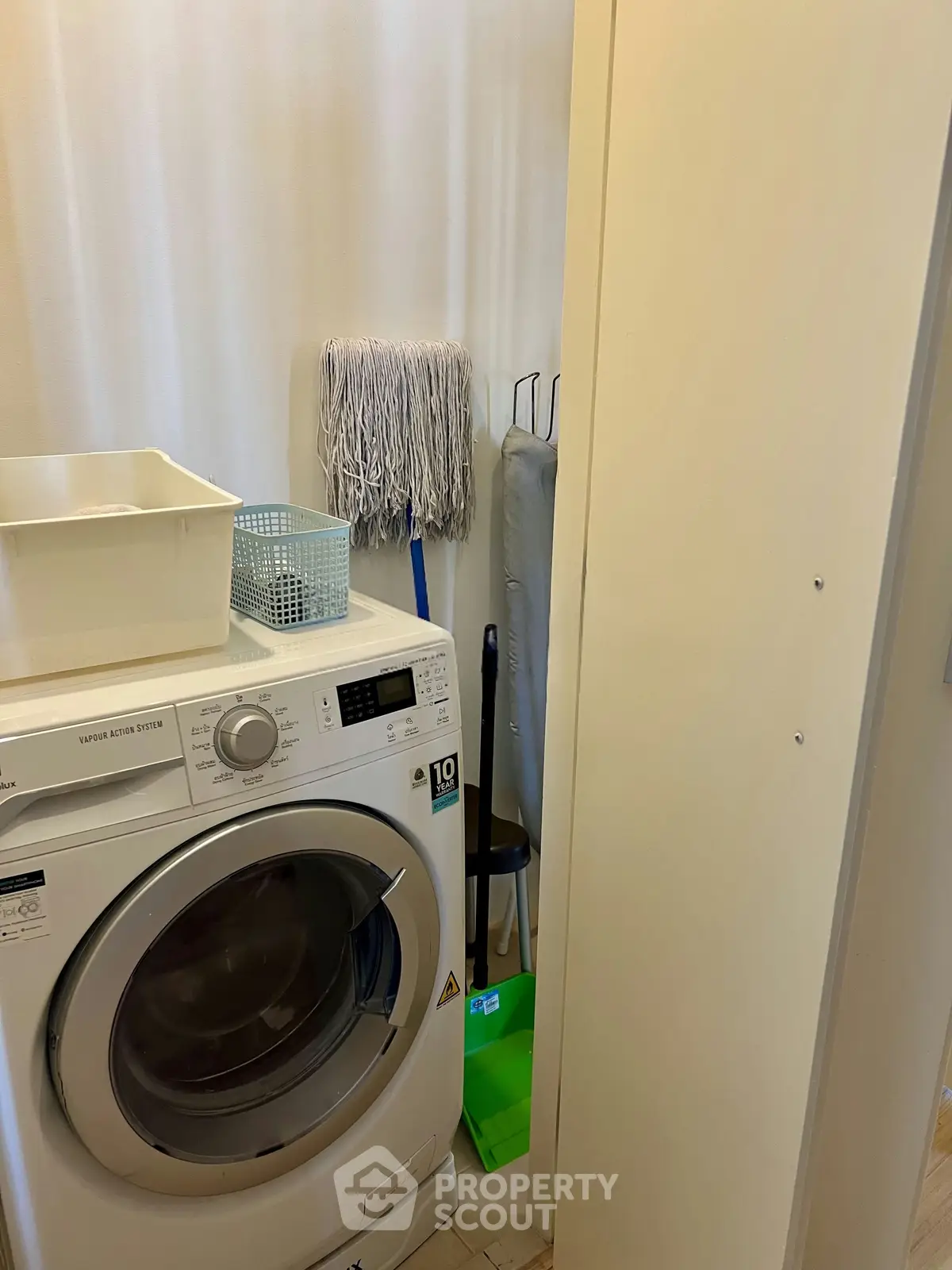 Compact laundry area with washing machine and cleaning supplies in modern home.