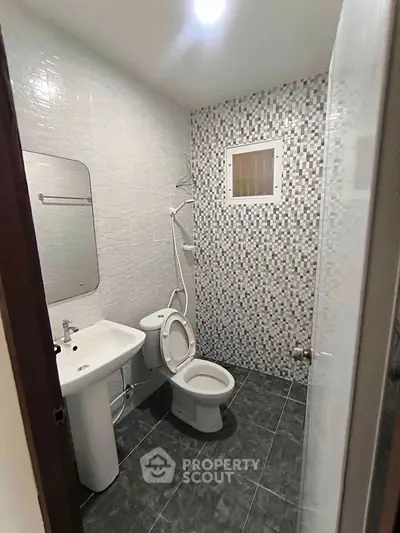 Modern bathroom with sleek tiles and contemporary fixtures in a stylish real estate property.