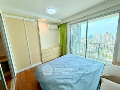 Bright bedroom with city view and large window, featuring modern furnishings and ample natural light.