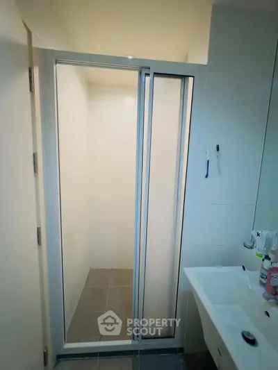 Modern bathroom with sleek shower enclosure and contemporary sink design.