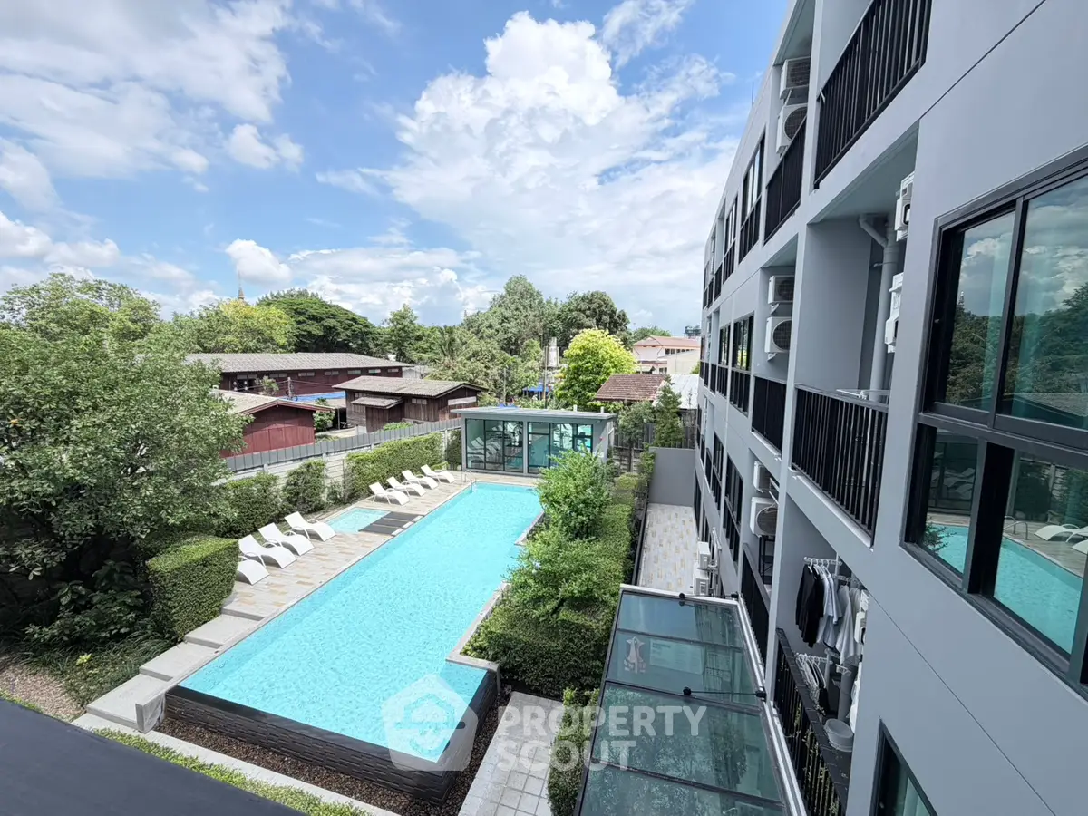 Modern apartment building with pool and lush greenery, perfect for relaxation and leisure.