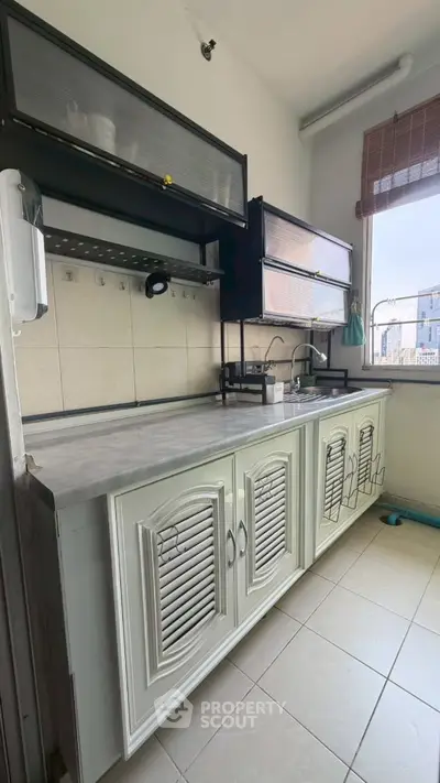 Modern kitchen with sleek cabinets and city view window, perfect for urban living.