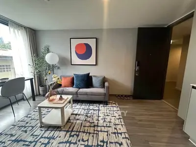 Modern living room with stylish decor and large window offering natural light.