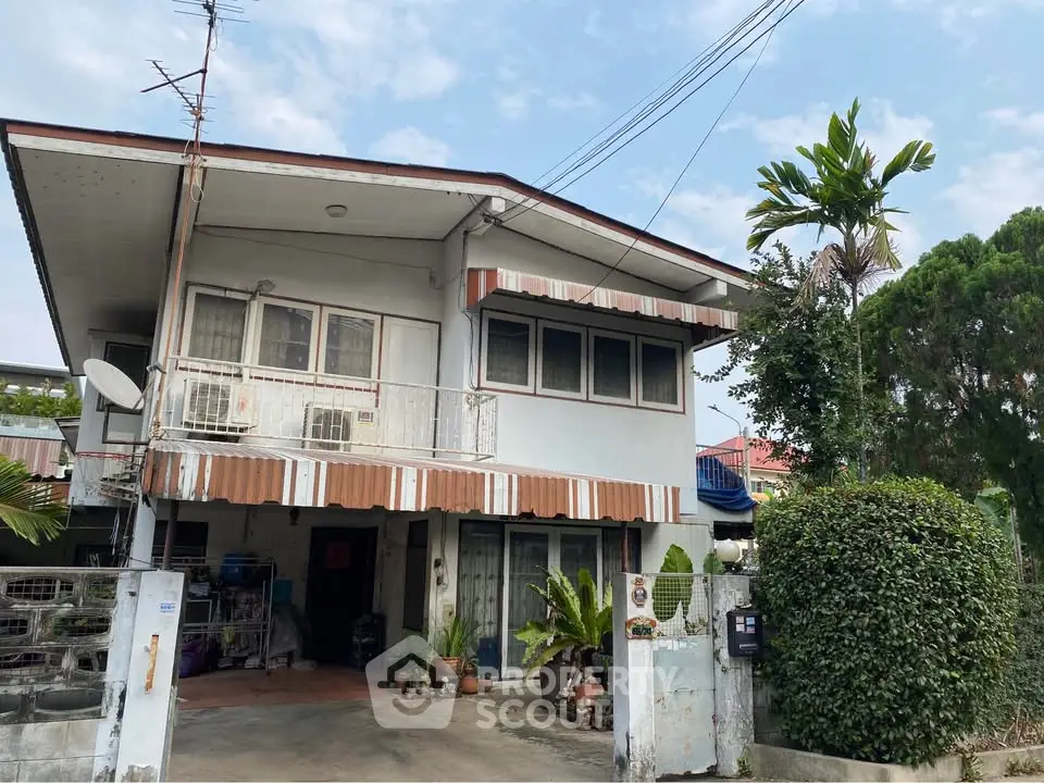 Charming two-story house with lush greenery and spacious driveway