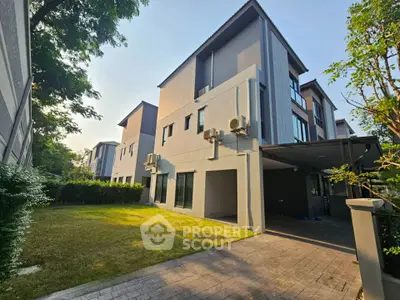 Modern multi-story townhouse with spacious garden and sleek exterior design.