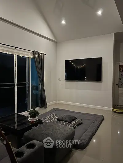 Modern living room with sleek TV setup and cozy seating area.