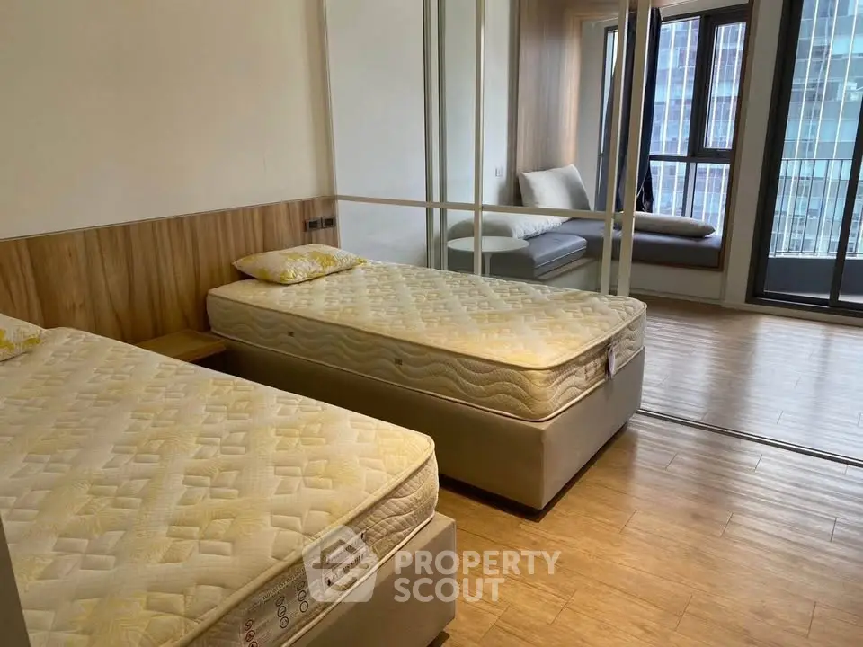 Spacious bedroom with twin beds and large windows in modern apartment
