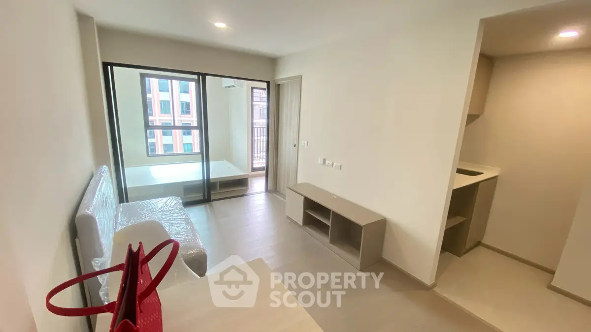Modern apartment interior with balcony, featuring sleek design and natural light.