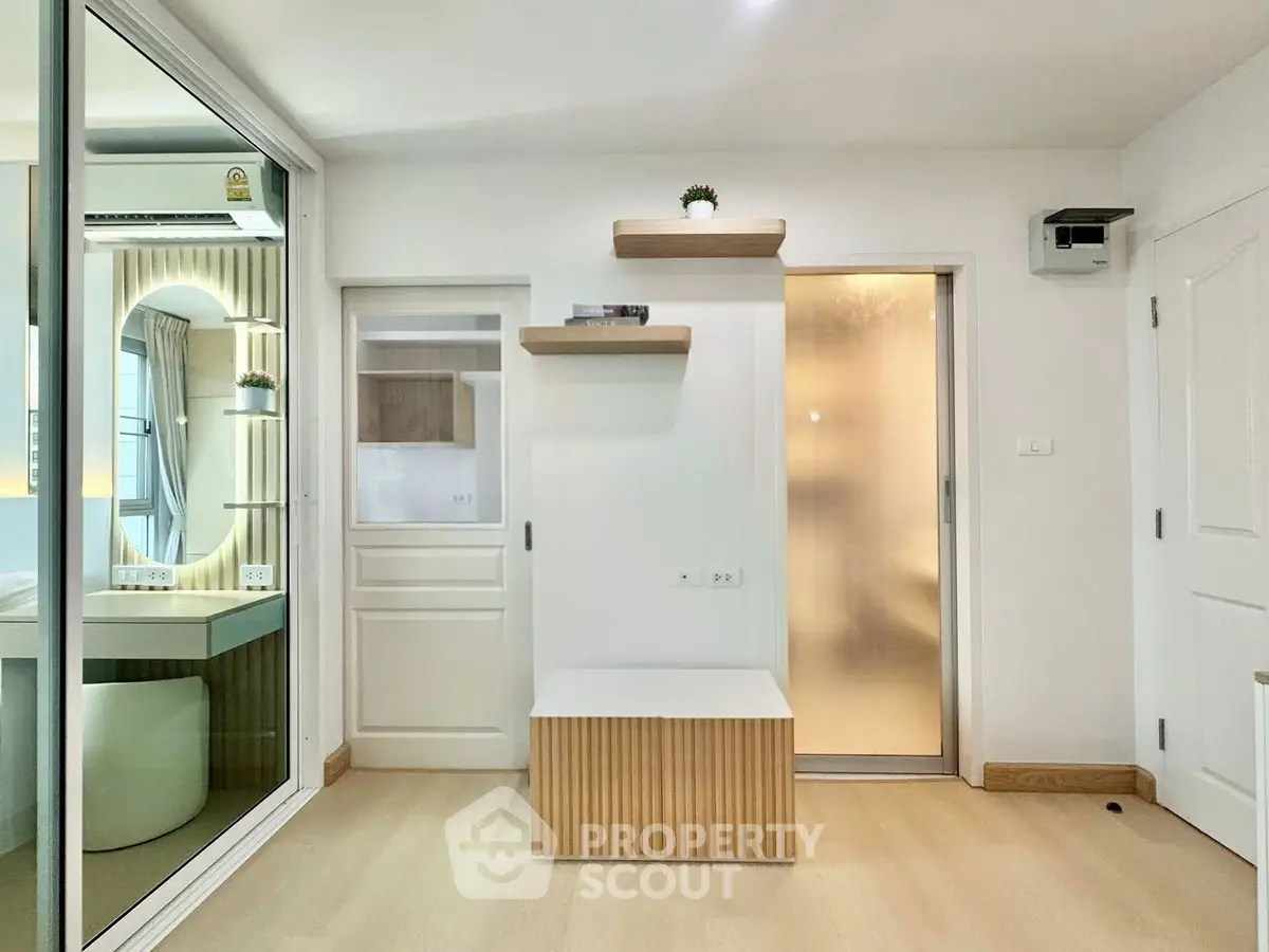 Modern minimalist interior with frosted glass door and stylish shelving in a bright room.