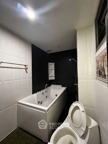 Modern bathroom with sleek bathtub and toilet in contemporary design.