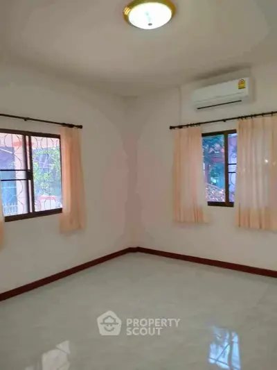 Bright empty room with air conditioning and large windows, perfect for customization.