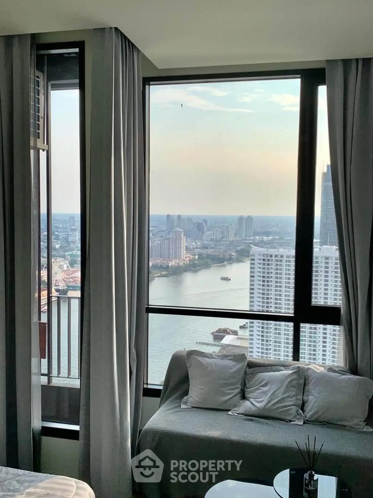Stunning high-rise apartment with panoramic river view and cozy seating area.