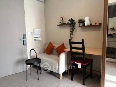 Cozy living room with modern decor, featuring a small sofa, stylish table, and decorative shelves.