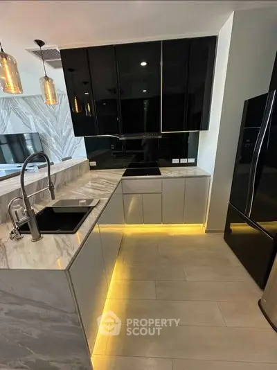 Modern kitchen with sleek black cabinets, marble countertops, and ambient lighting
