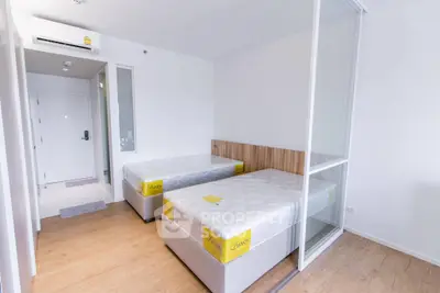 Modern bedroom with twin beds and glass partition in a minimalist apartment.