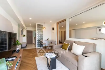 Modern living room with stylish decor and open layout, featuring a cozy sofa and elegant lighting.