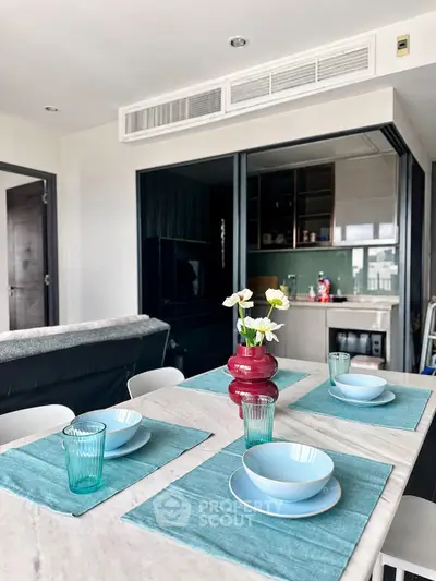Modern dining area with elegant table setting and open kitchen layout in a stylish apartment.