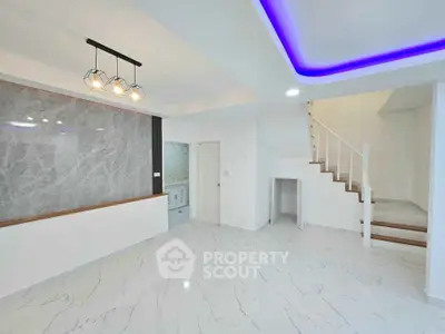 Modern open-plan living space with marble flooring and stylish lighting