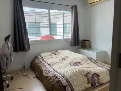 Cozy bedroom with large window and air conditioning, featuring a comfortable bed and modern decor.