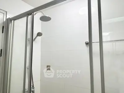 Modern bathroom with sleek glass shower enclosure and dual shower heads.