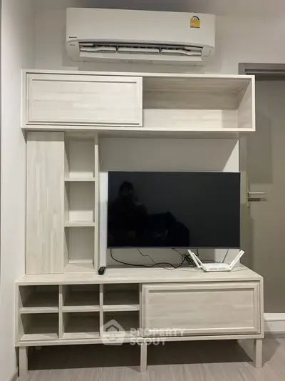 Modern living room with sleek TV stand and air conditioning unit, perfect for comfortable living.