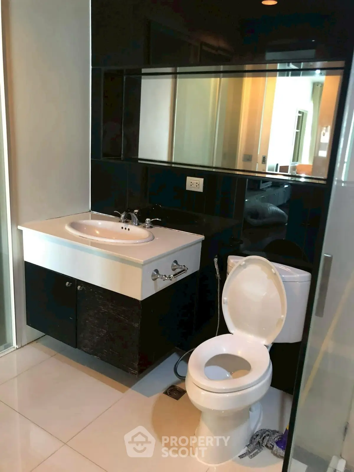 Modern bathroom with sleek black and white design, featuring a stylish sink and toilet.