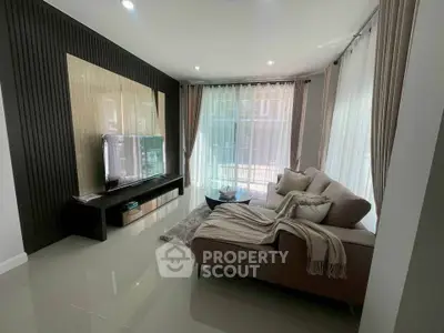 Modern living room with sleek furniture and large windows for natural light.