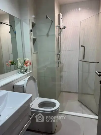 Modern bathroom with glass shower and sleek fixtures in a contemporary apartment.