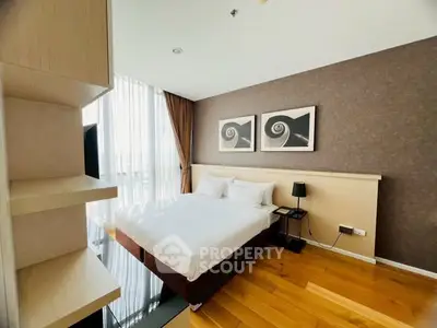 Modern bedroom with stylish decor and large window for natural light.