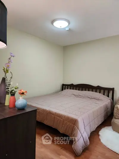 Cozy bedroom with wooden flooring and elegant decor, perfect for relaxation.