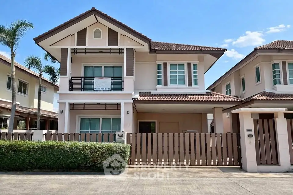 Charming two-story house with a modern design, featuring a fenced yard and lush greenery, perfect for family living.