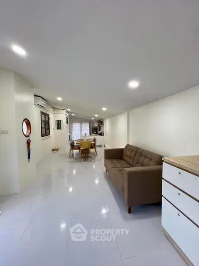 Spacious open-plan living area with modern furniture and bright lighting