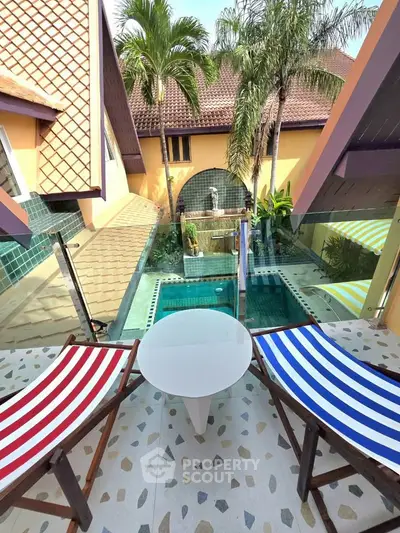 Charming balcony with pool view and tropical vibe, perfect for relaxation.