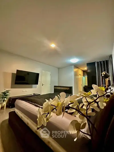 Luxurious bedroom with modern decor and large TV, perfect for relaxation and comfort.