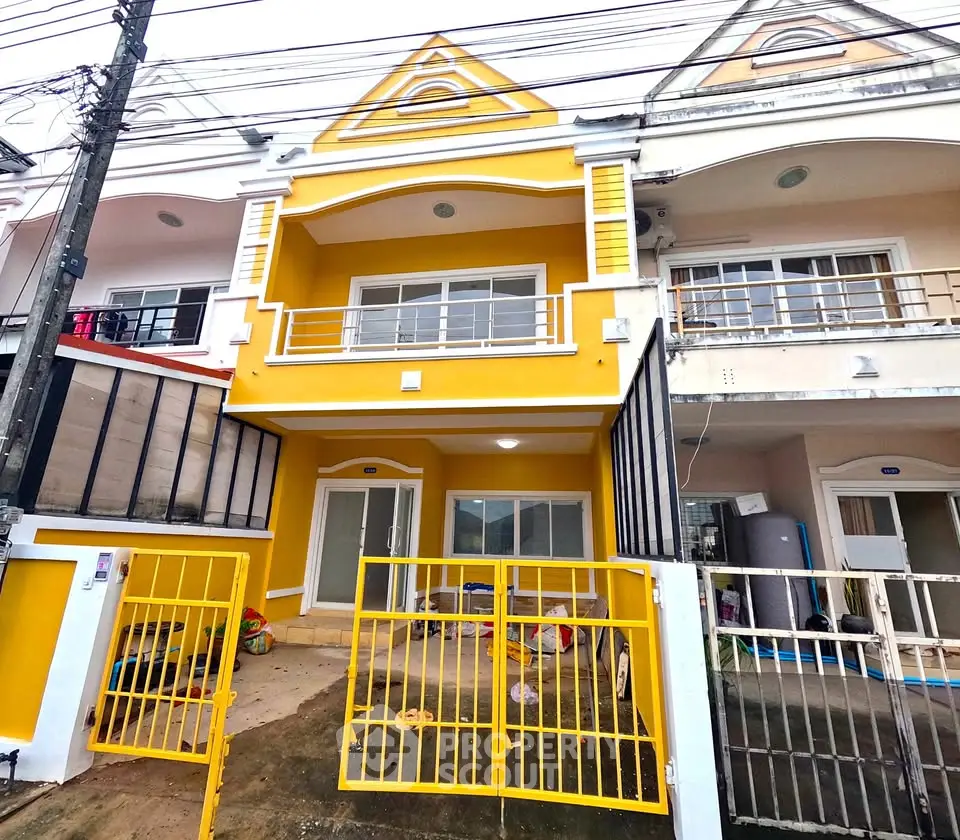 Charming yellow townhouse with gated entrance and modern facade