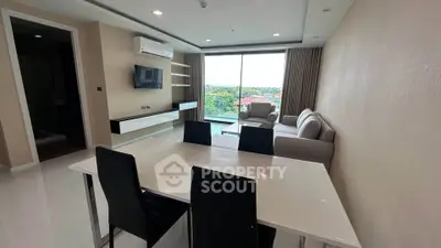 Modern living room with sleek furniture and large window offering scenic views.