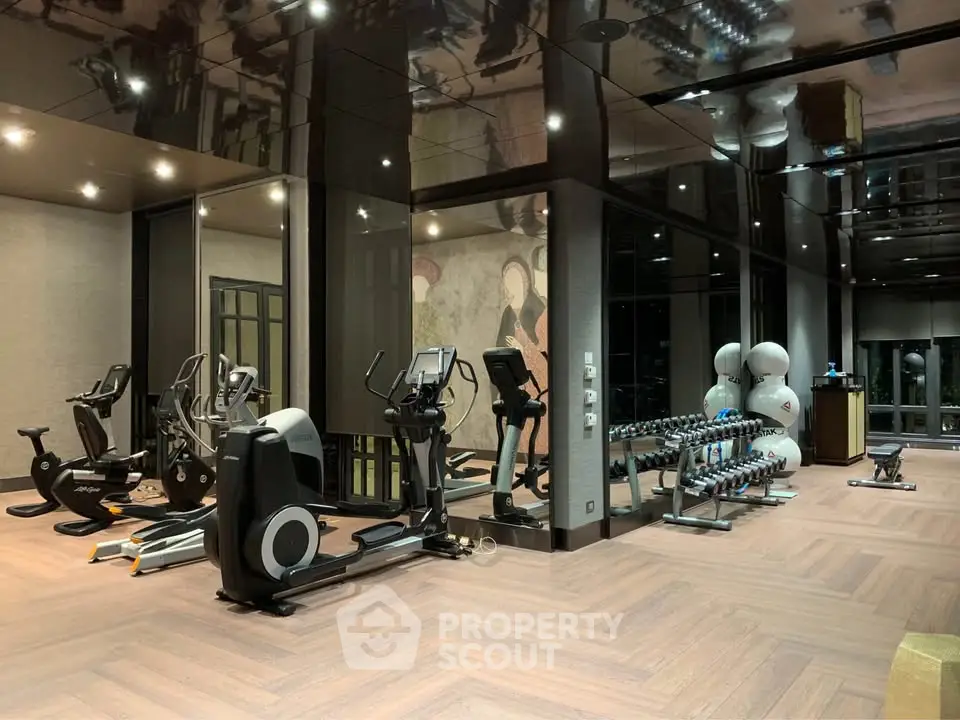 Luxurious gym with modern equipment and elegant design in upscale residential building.
