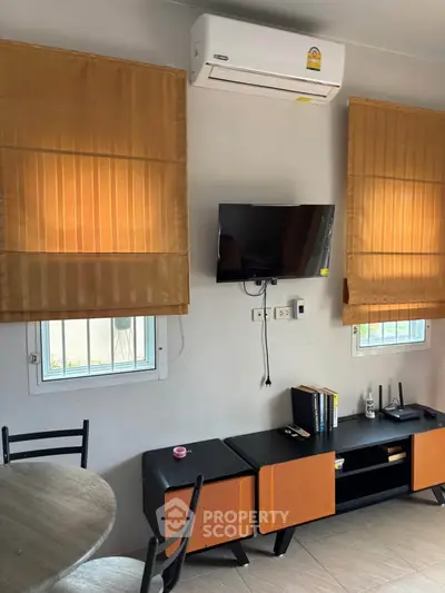 Modern living room with air conditioning and stylish orange accents
