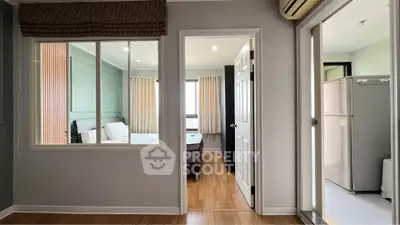 Spacious apartment interior with bedroom and kitchen view, featuring modern decor and wooden flooring.