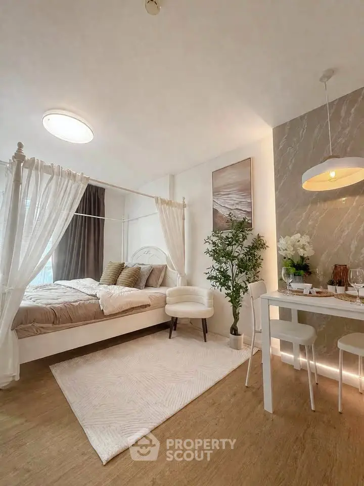 Elegant bedroom with canopy bed and dining area, featuring modern decor and natural light.