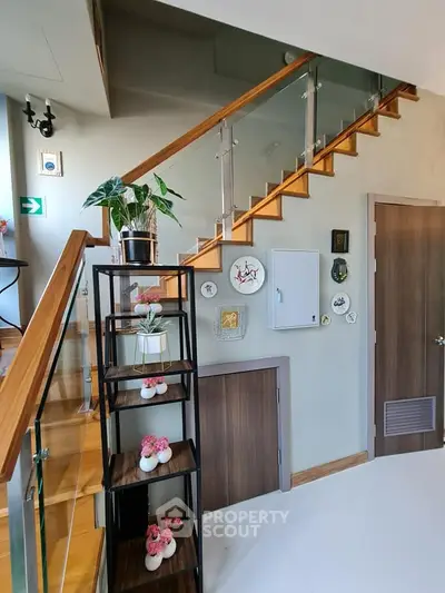 Stylish modern staircase with decorative shelving and wall art in a contemporary home interior.