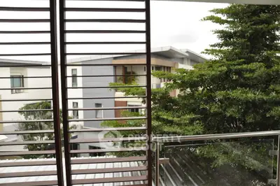Modern balcony with glass railing and lush greenery view