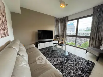 Modern living room with large window and city view, featuring stylish furniture and decor.