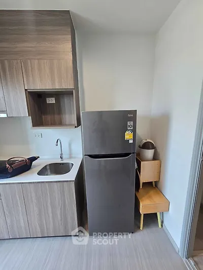 Modern kitchen with sleek fridge and stylish cabinetry in compact layout