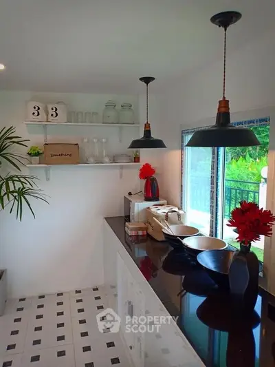 Charming kitchen with open layout, modern lighting, and lush garden view, perfect for culinary enthusiasts.